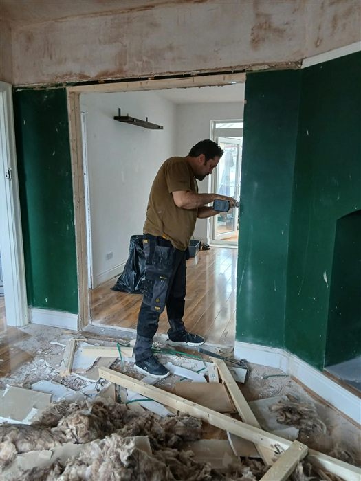 On site during a renovation, fitting the lining of a newly widened doorway between two rooms