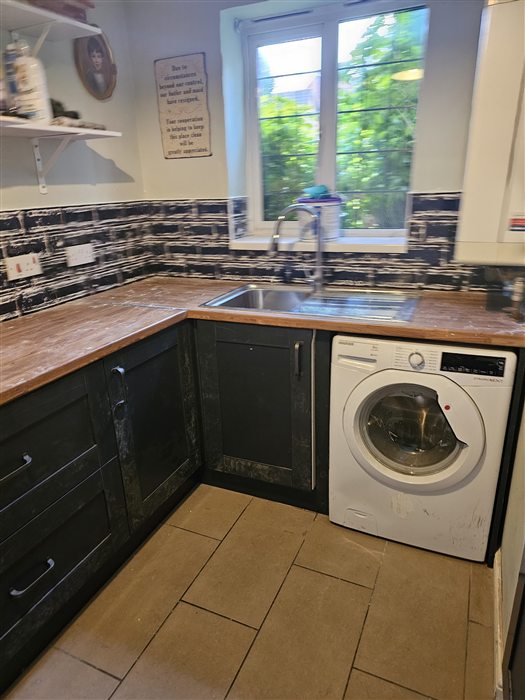 Same kitchen after: navy shaker units and oak-look worktop