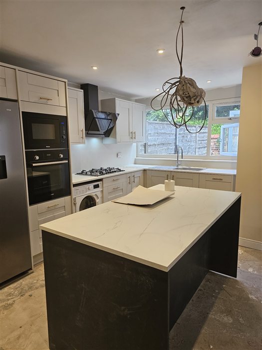Kitchen with a dark island and white quartz-effect top