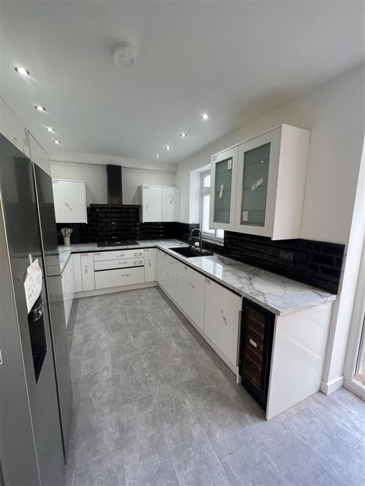 White gloss kitchen with black worktops and splashback