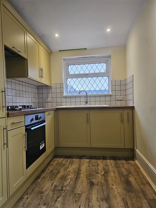 Pale yellow shaker kitchen with wood-effect worktop